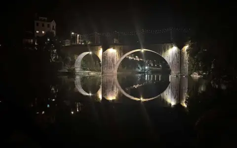 Puente de São Gonçalo iluminado y reflejado en el río