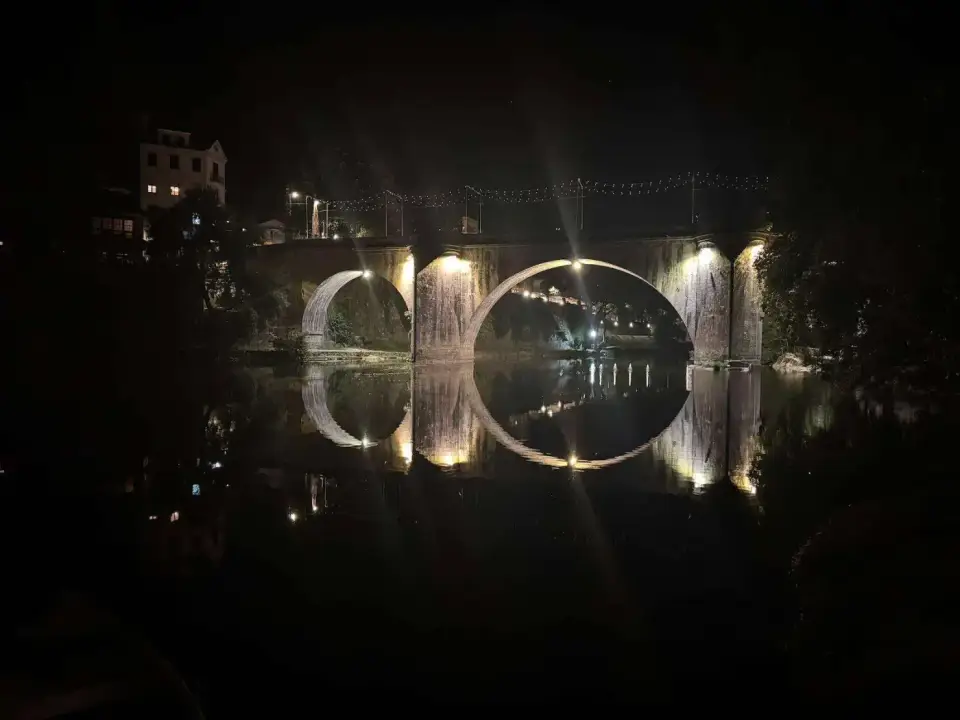 Puente de São Gonçalo iluminado y reflejado en el río