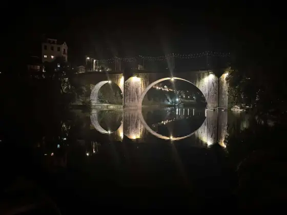 Puente de São Gonçalo iluminado y reflejado en el río