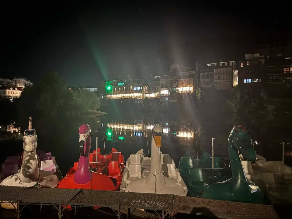Botes a pedal con forma de cisne en el río de noche