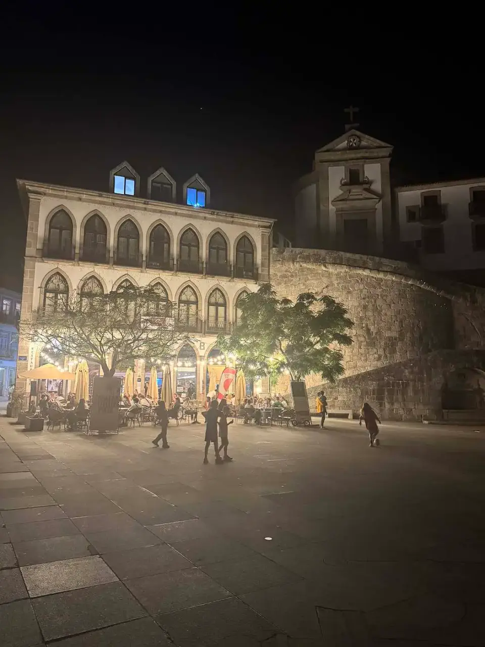 Plaza de Amarante iluminada de noche con gente paseando
