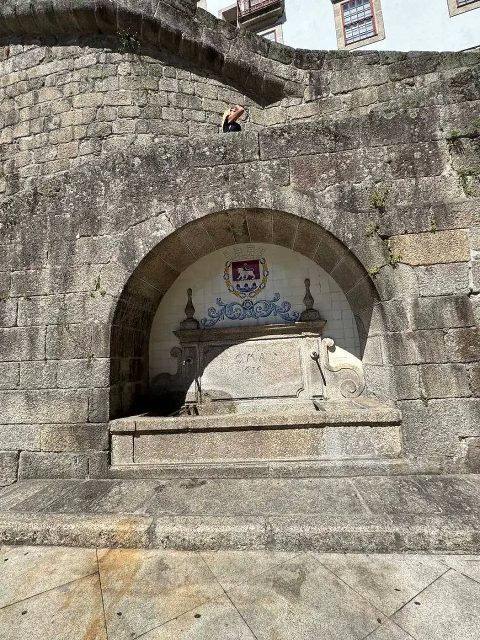 Antigua fuente de piedra con escudo de azulejos en Amarante