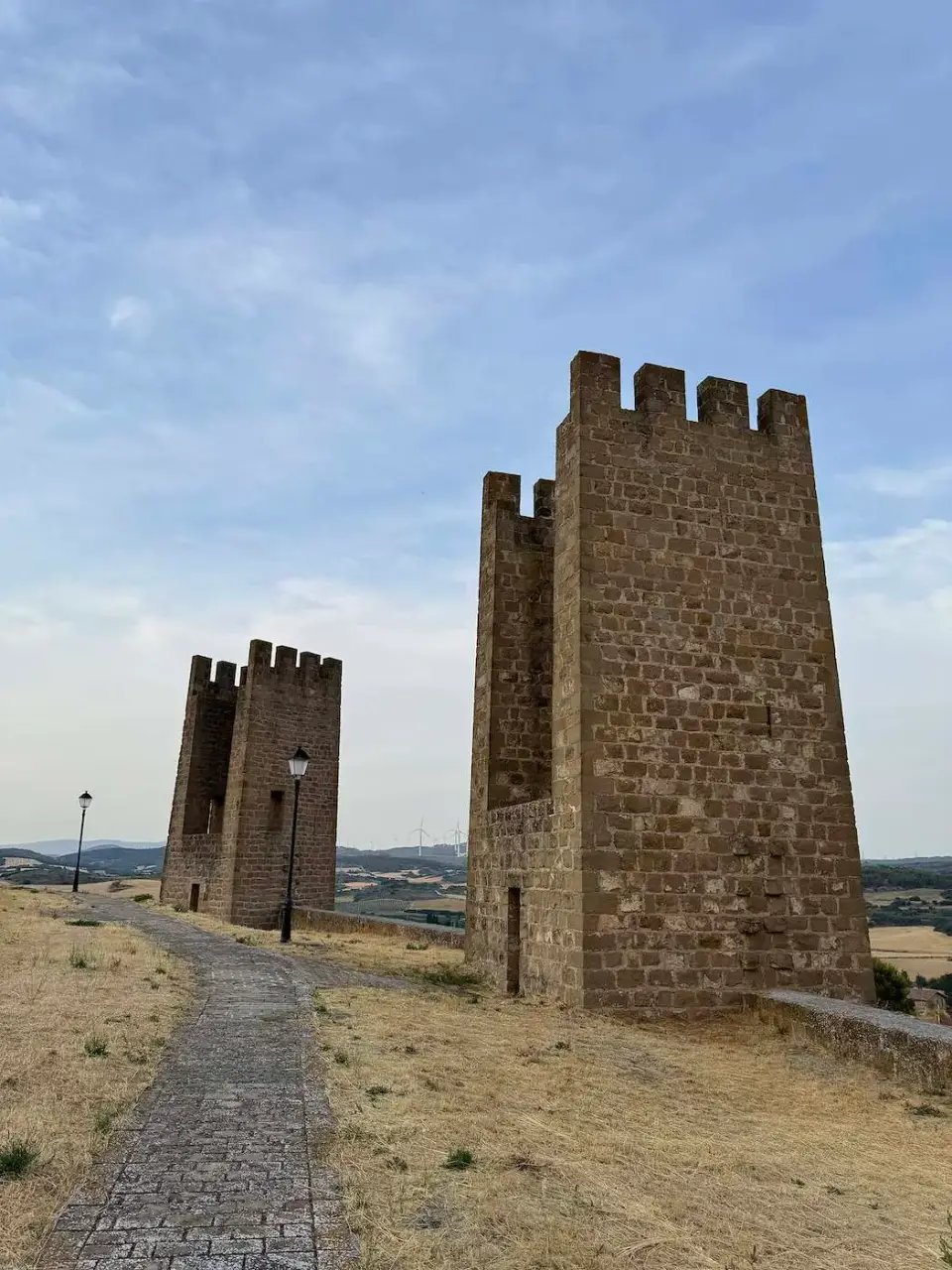 Dos torreones de la muralla medieval junto a un sendero