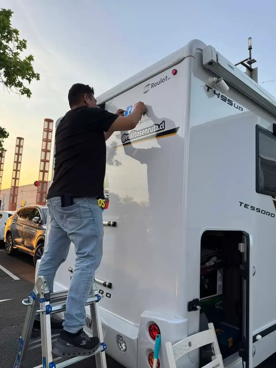 Instalando adhesivos en la autocaravana al atardecer