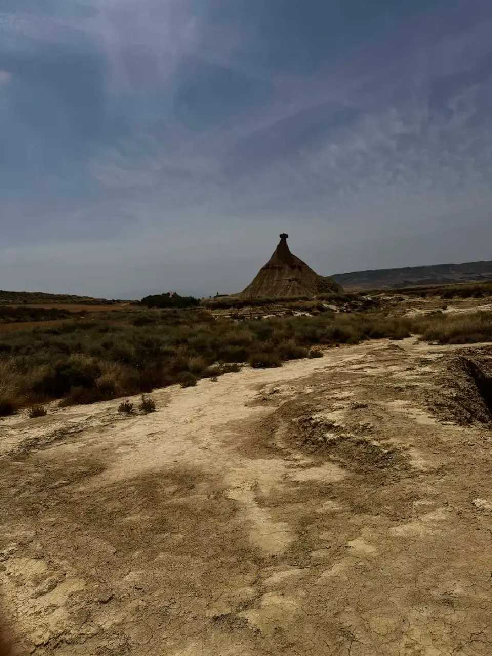 Castildetierra a lo lejos sobre el terreno erosionado del desierto