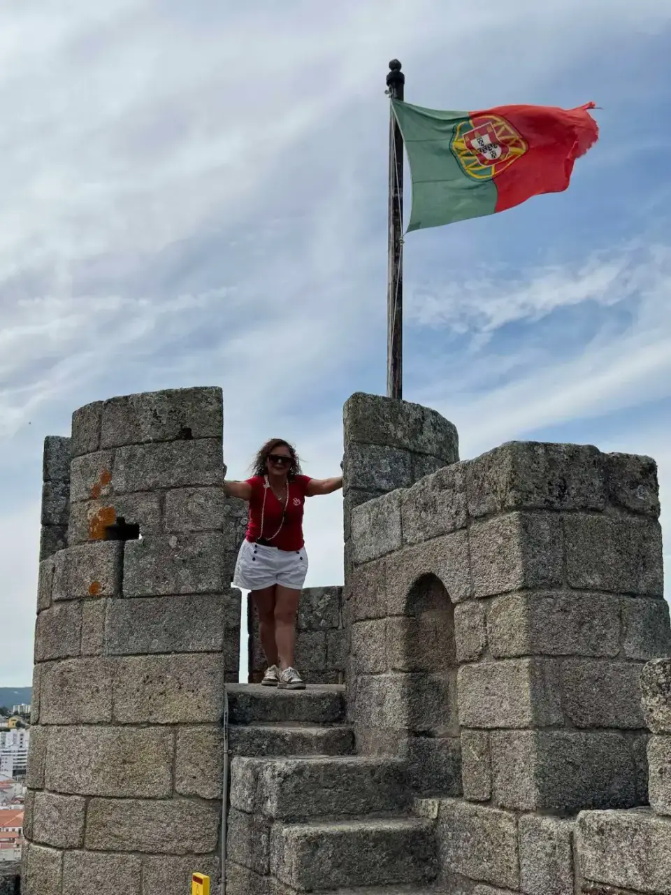 Paola en lo alto de la muralla con la bandera de Portugal