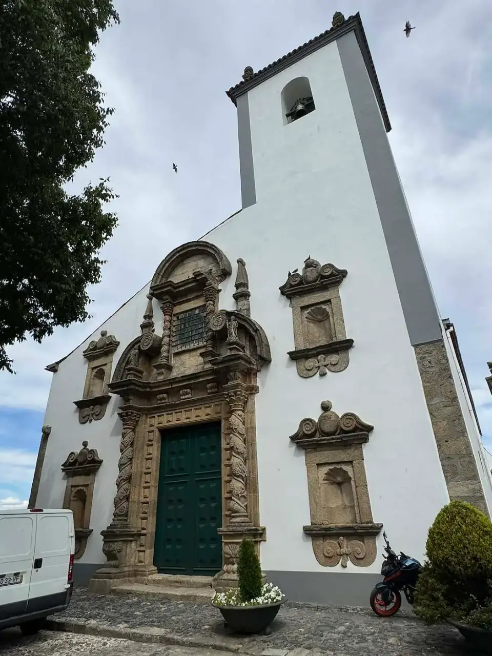 Iglesia blanca con portada barroca de piedra