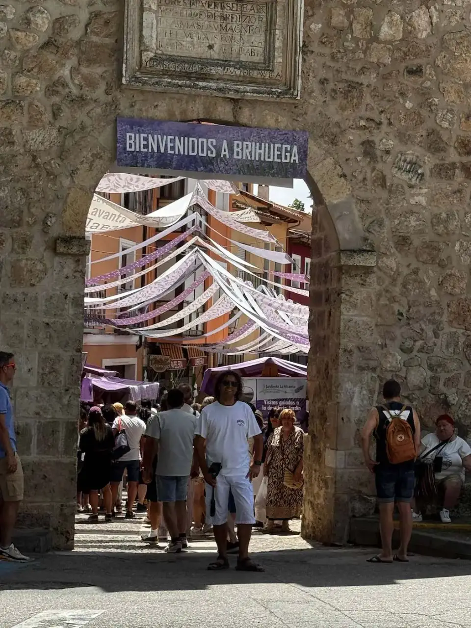 Arco de entrada a Brihuega decorado y lleno de gente