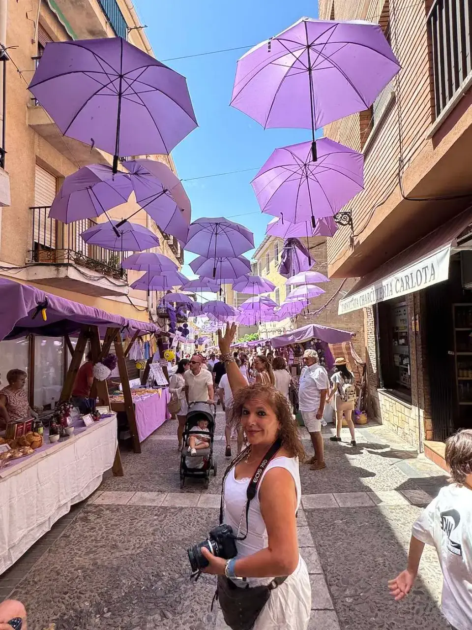 Paola recorre una calle cubierta de sombrillas moradas