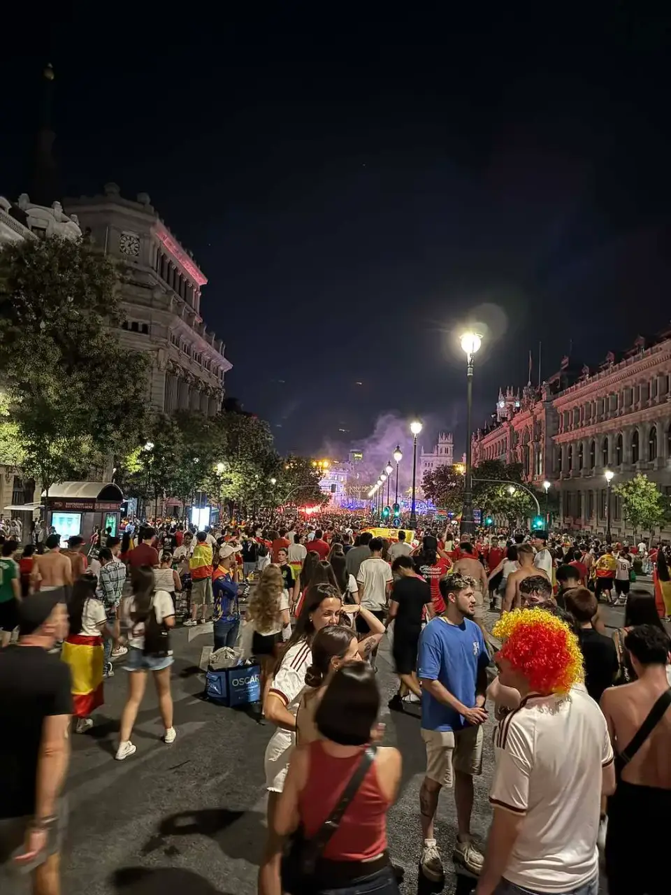 Calle llena de gente celebrando de noche