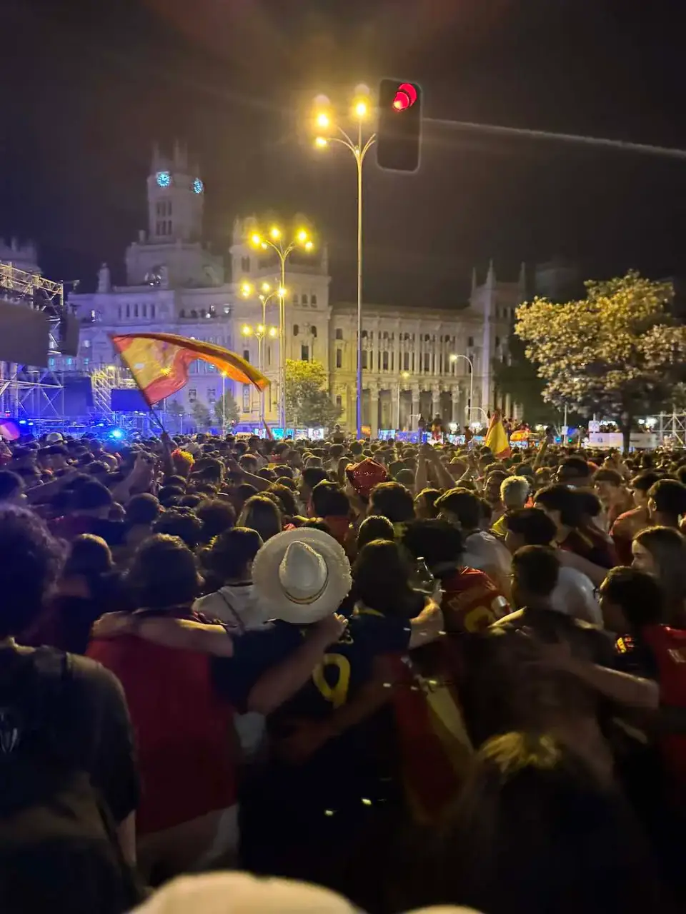 Multitud celebrando de noche frente a un palacio iluminado