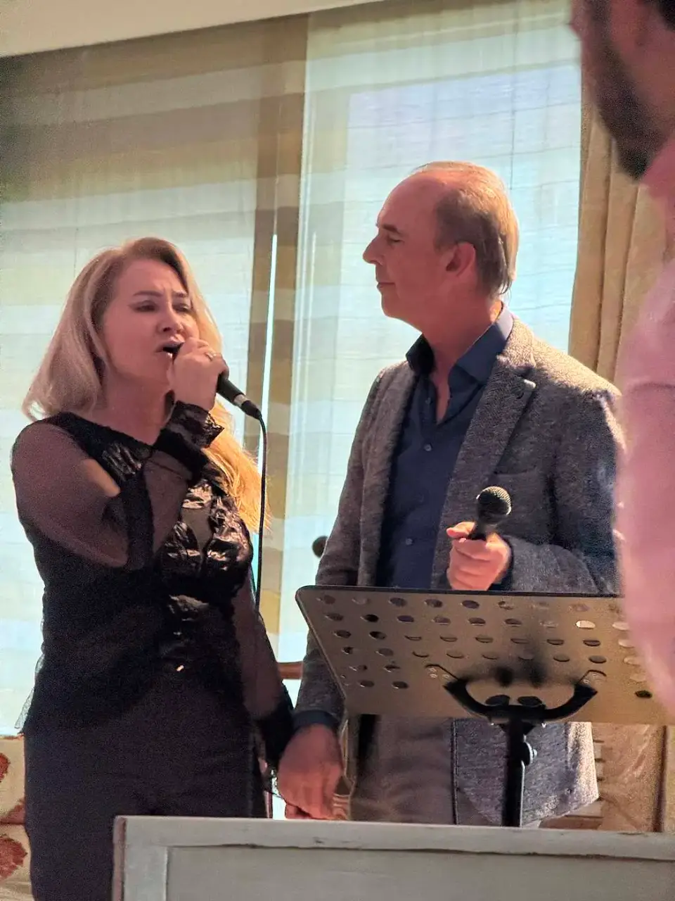 Una amiga y un amigo cantan durante la velada
