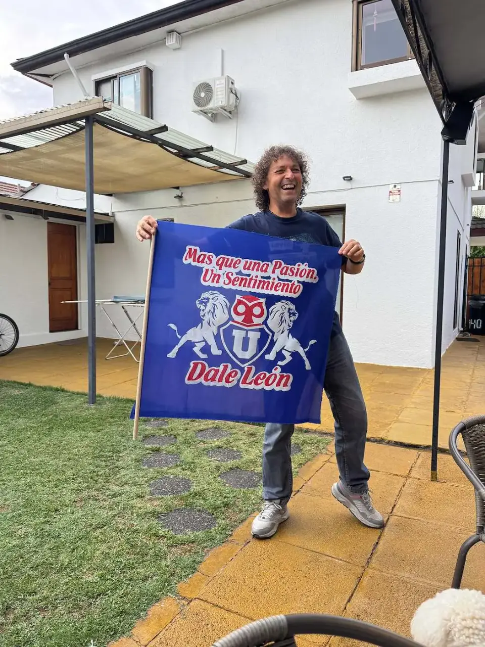 Jorge sostiene una bandera azul en el patio