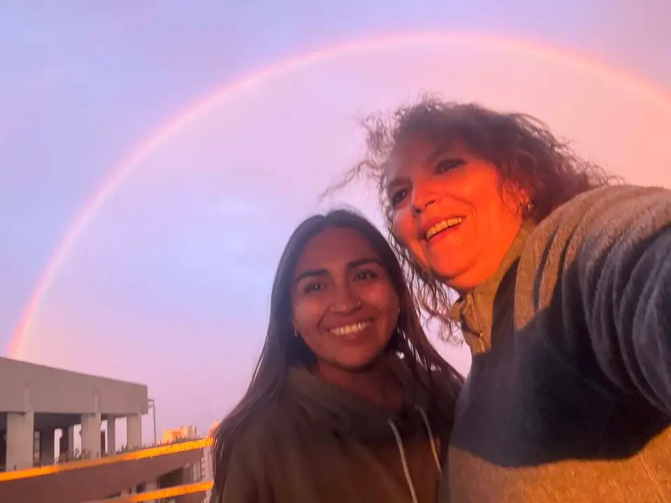 Selfie de Paola con una joven bajo un arcoíris