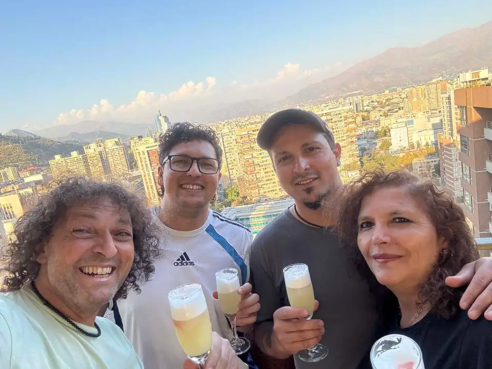 Jorge y Paola brindan con amigos con vista a la ciudad