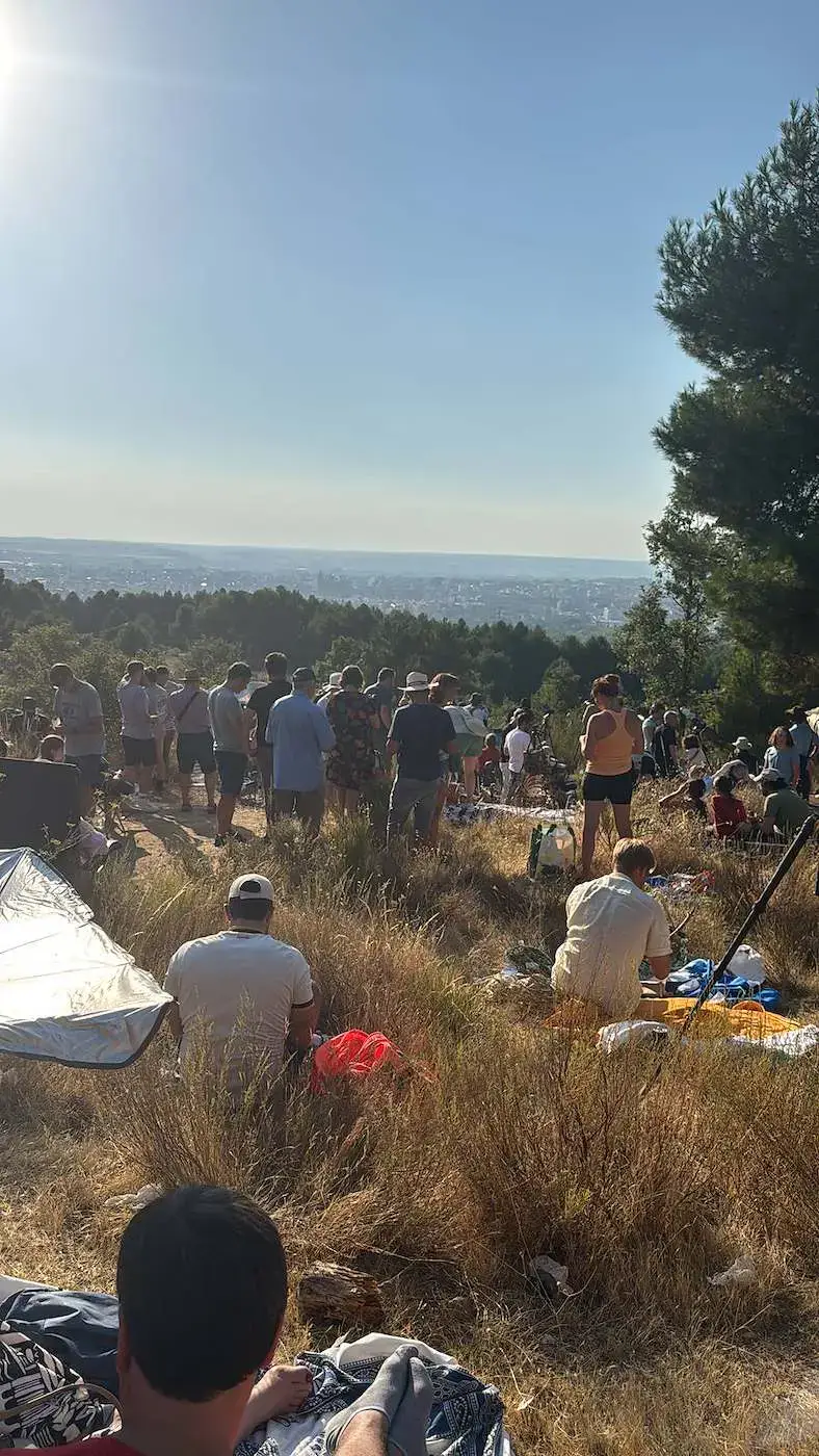 Gente reunida en el cerro esperando el eclipse