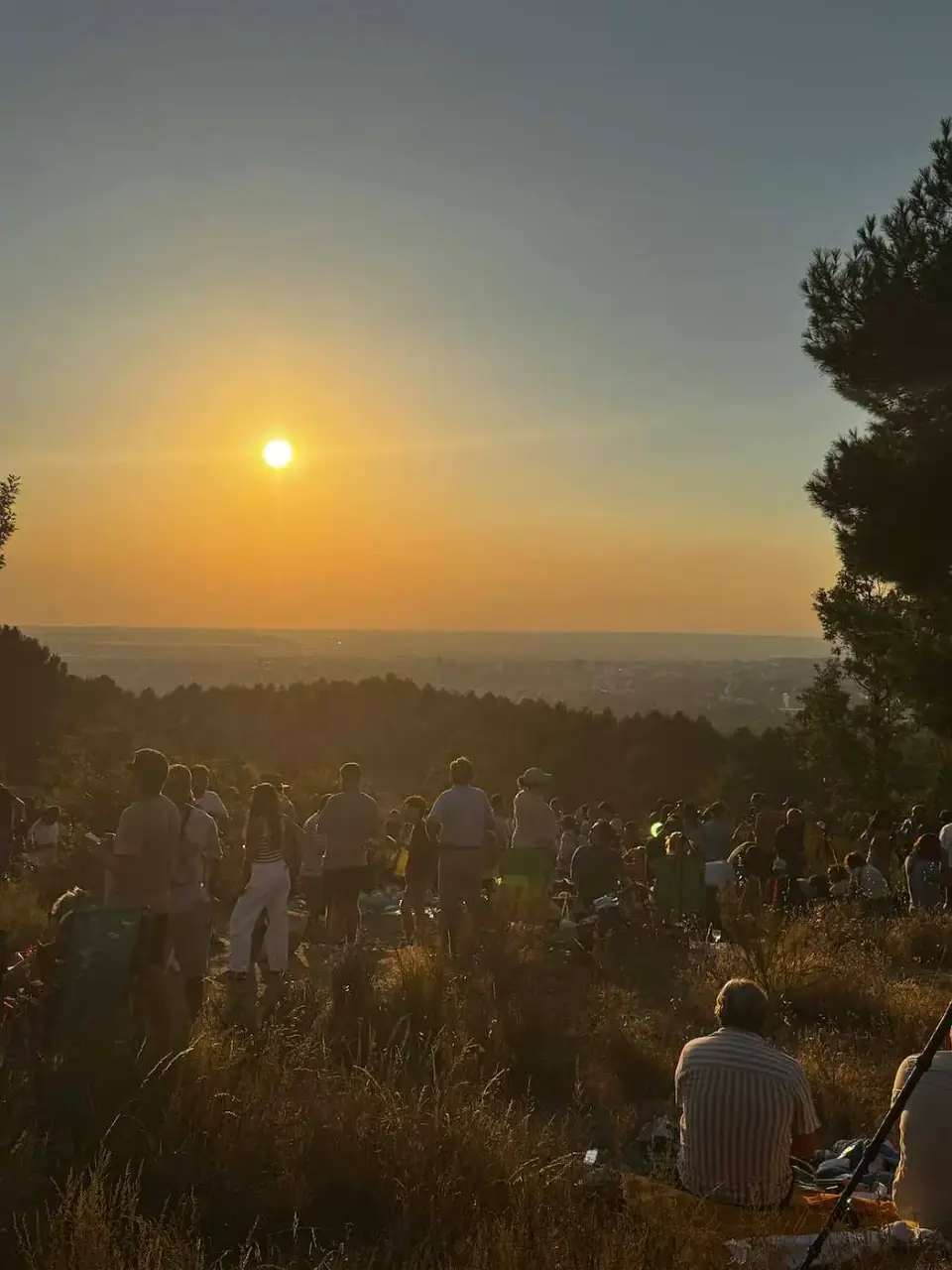 Público sentado en el cerro mirando el sol antes del eclipse