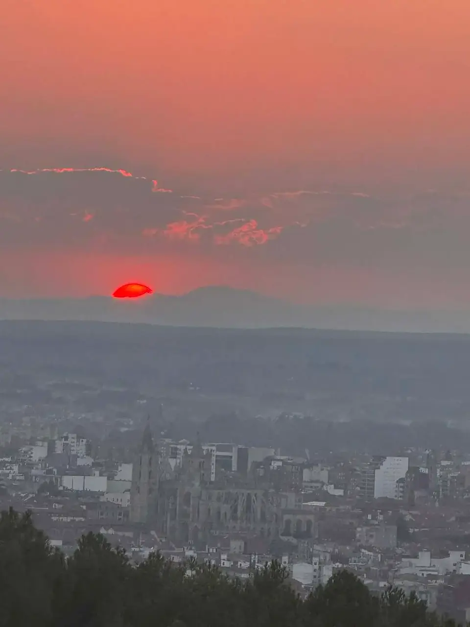 Sol rojo del eclipse ocultándose tras los cerros de León
