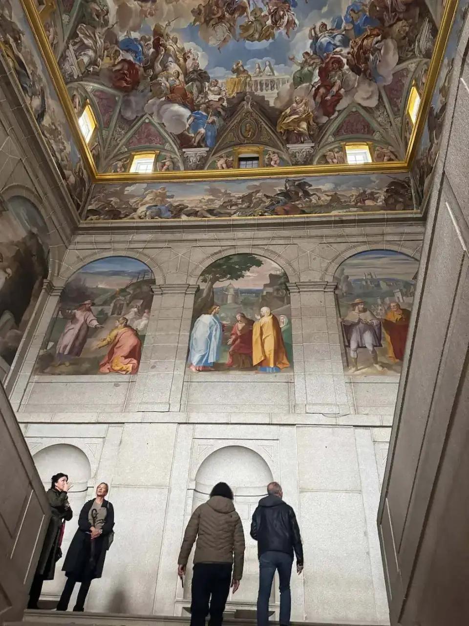 Visitantes admirando los frescos de una sala del monasterio