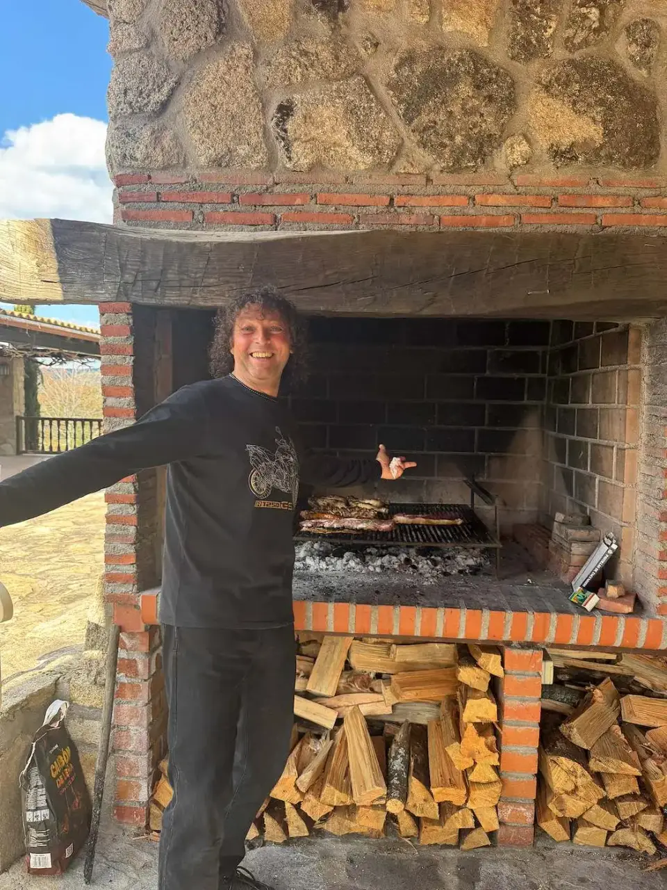 Jorge junto a la parrilla de leña
