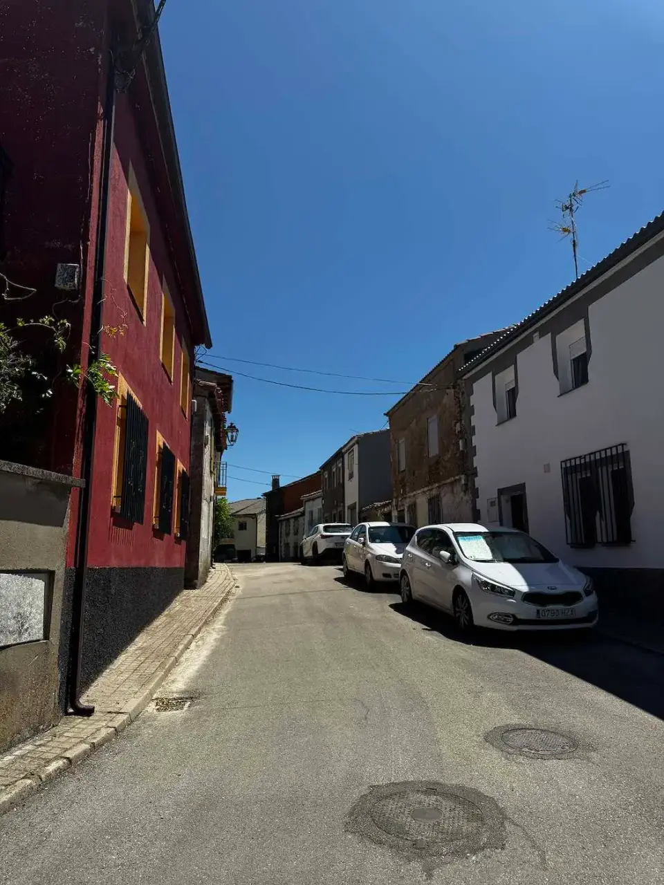 Calle del pueblo con casas y autos estacionados