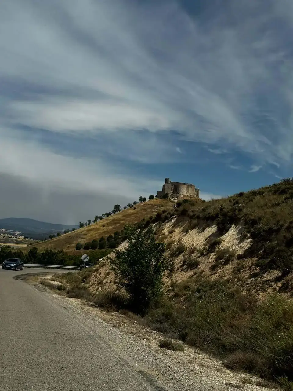 Carretera hacia el cerro del castillo bajo un cielo nublado