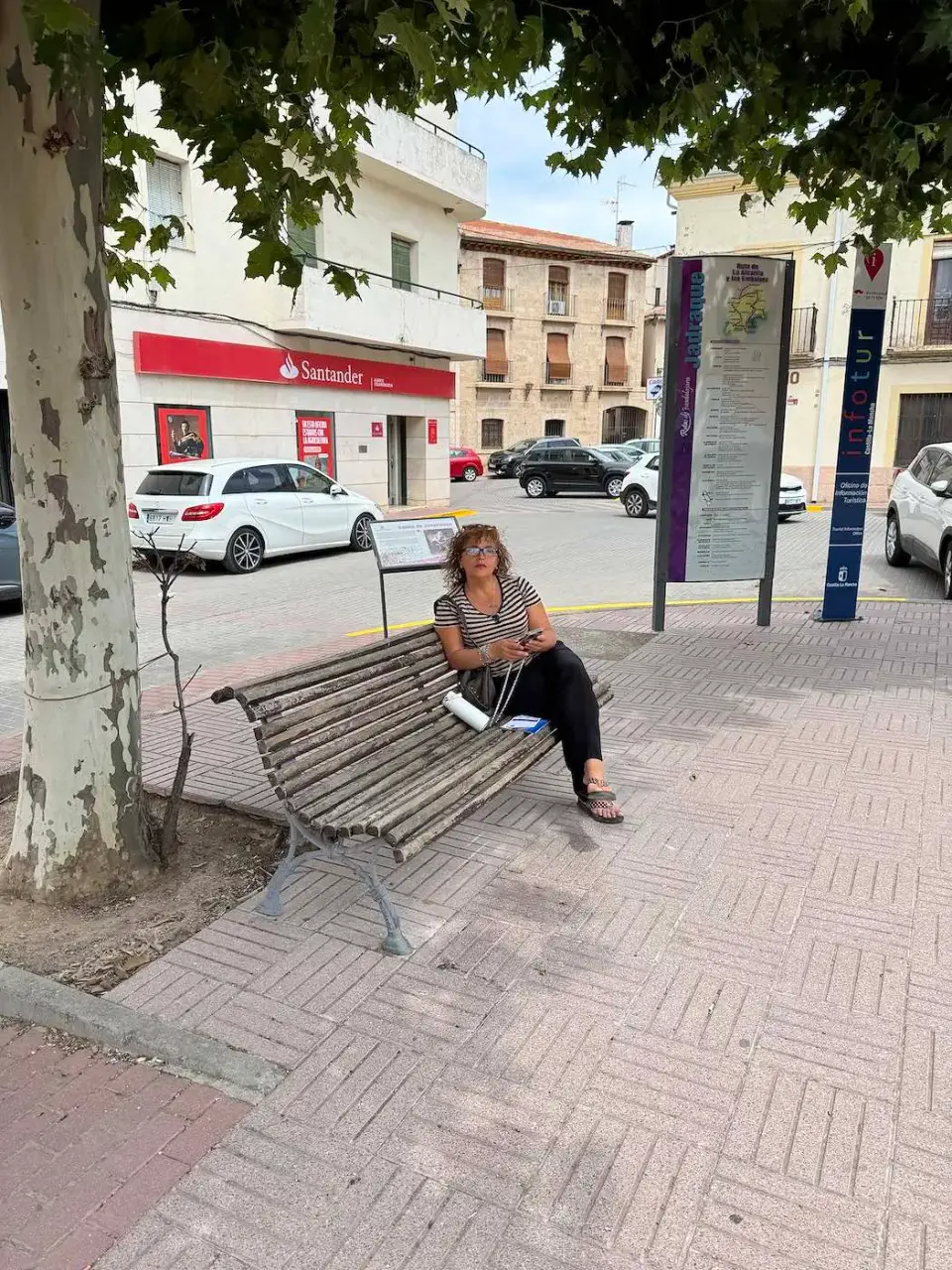Paola descansa en un banco de la plaza del pueblo