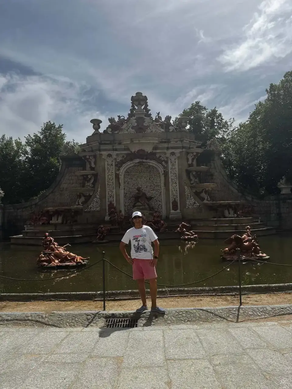 Jorge frente a una fuente barroca de los jardines