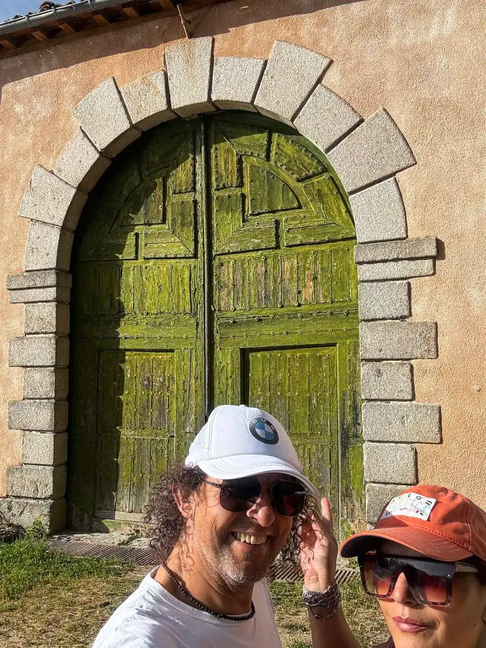 Jorge y Paola junto a una antigua puerta de madera verde