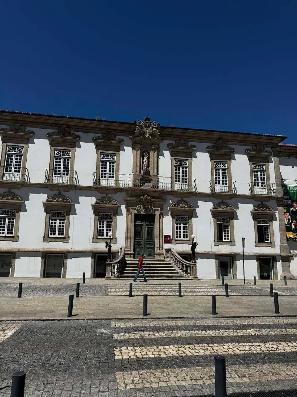 Fachada blanca de un edificio histórico con ventanas de piedra