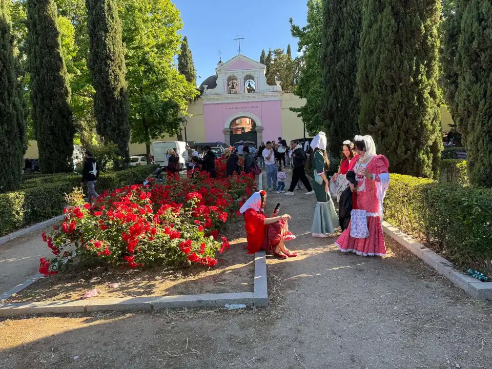 Mujeres vestidas de chulapa en un jardín con flores