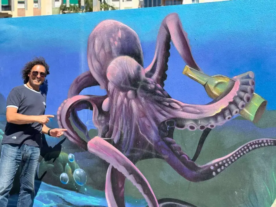Jorge frente a un mural de un pulpo gigante