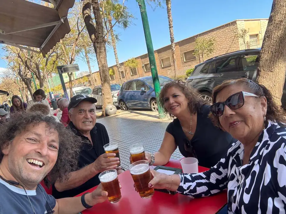 Jorge y amigos brindan con cerveza en una terraza