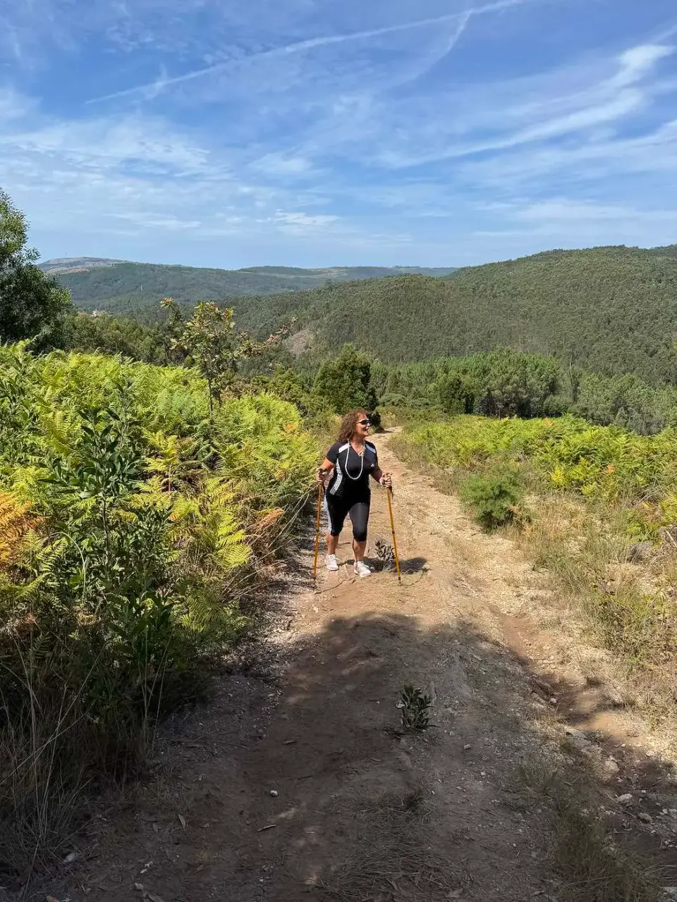 Caminata por un sendero de tierra entre cerros verdes