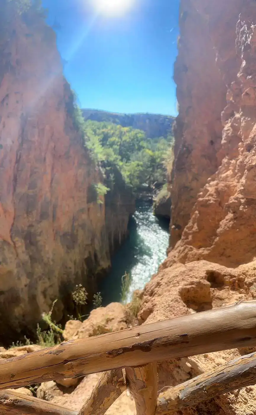 Cañón rocoso con barandas de madera bajo el cielo despejado