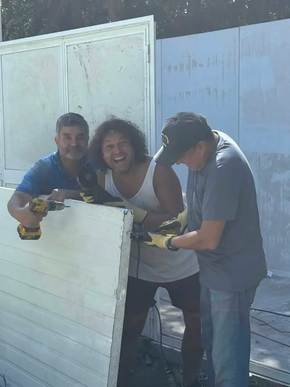 Amigos sostienen un panel mientras arman la bodega