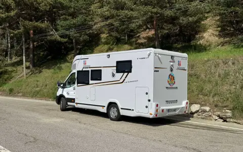 La autocaravana estacionada en un camino de montaña