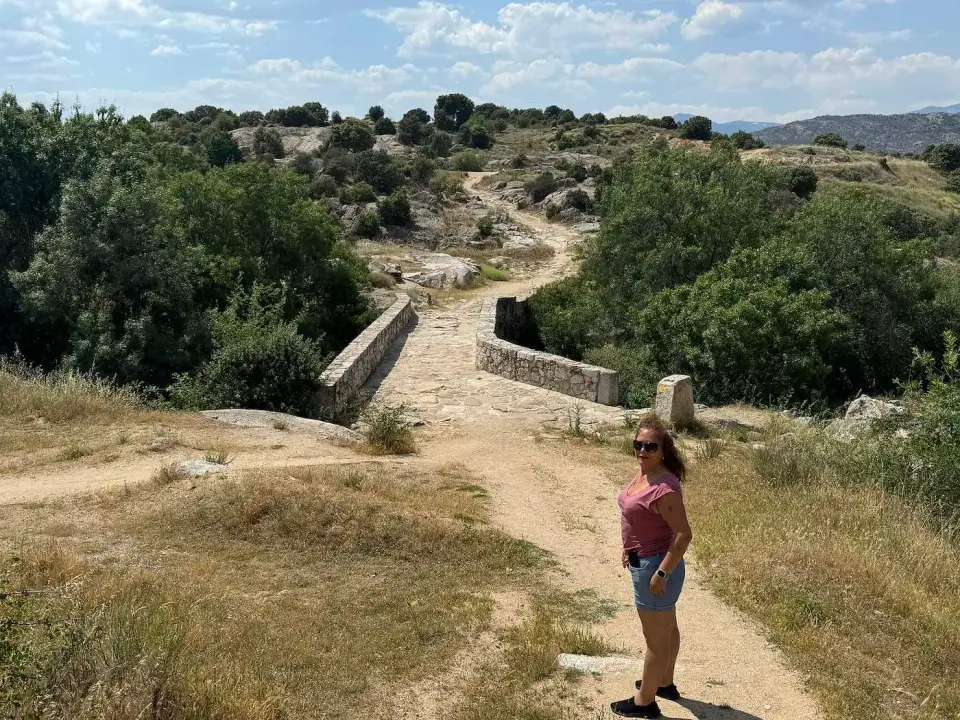 Sendero hacia un antiguo puente de piedra en la sierra