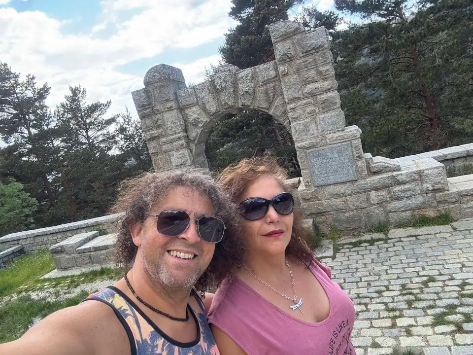 Jorge y Paola junto a un monumento de piedra en la sierra