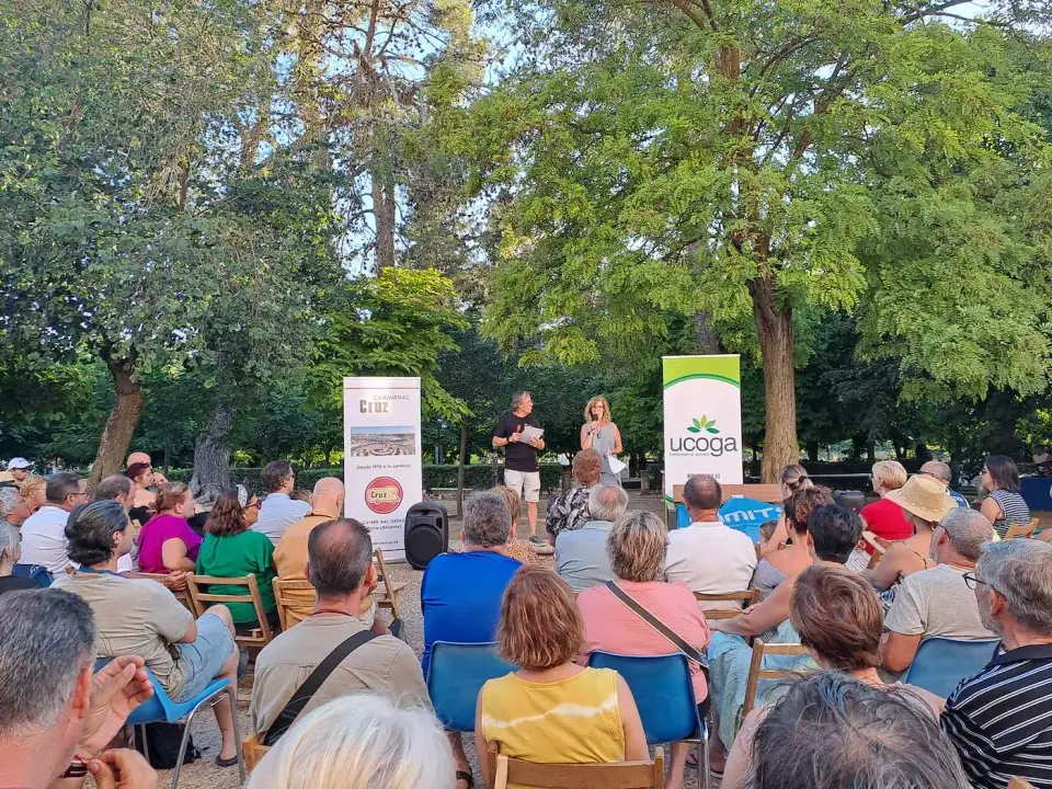 Autocaravanistas reunidos bajo los árboles durante el encuentro