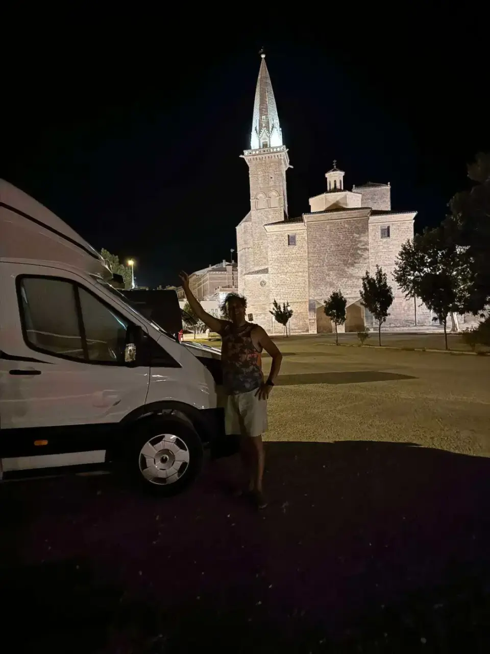 La autocaravana de noche junto a una iglesia iluminada