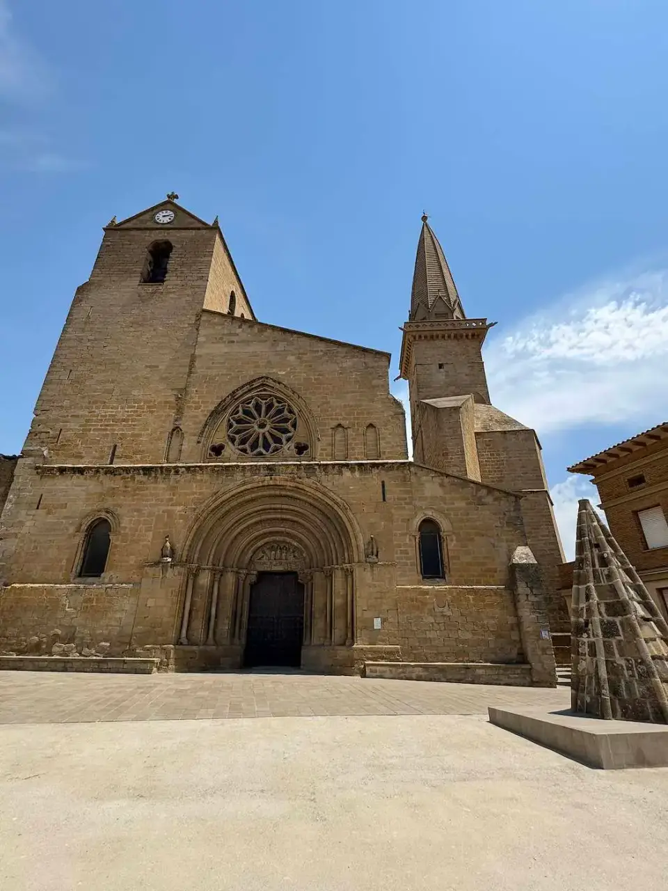 Fachada de una iglesia de piedra con rosetón y torre