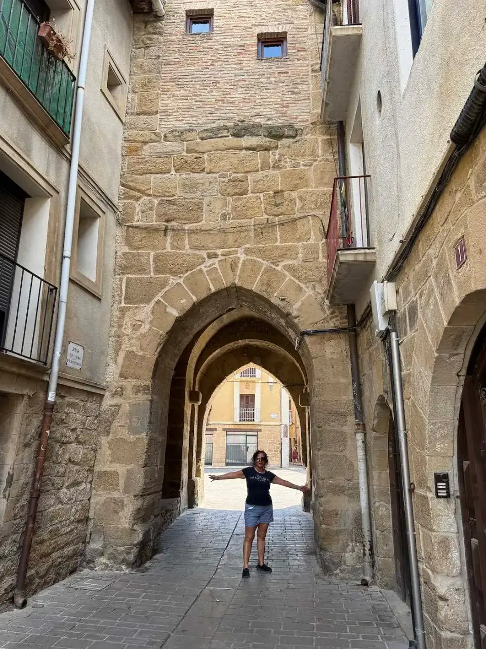Paola bajo un arco de piedra en el casco antiguo