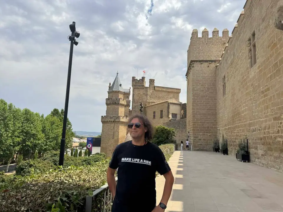 Hombre de pelo largo frente a las murallas del Palacio Real