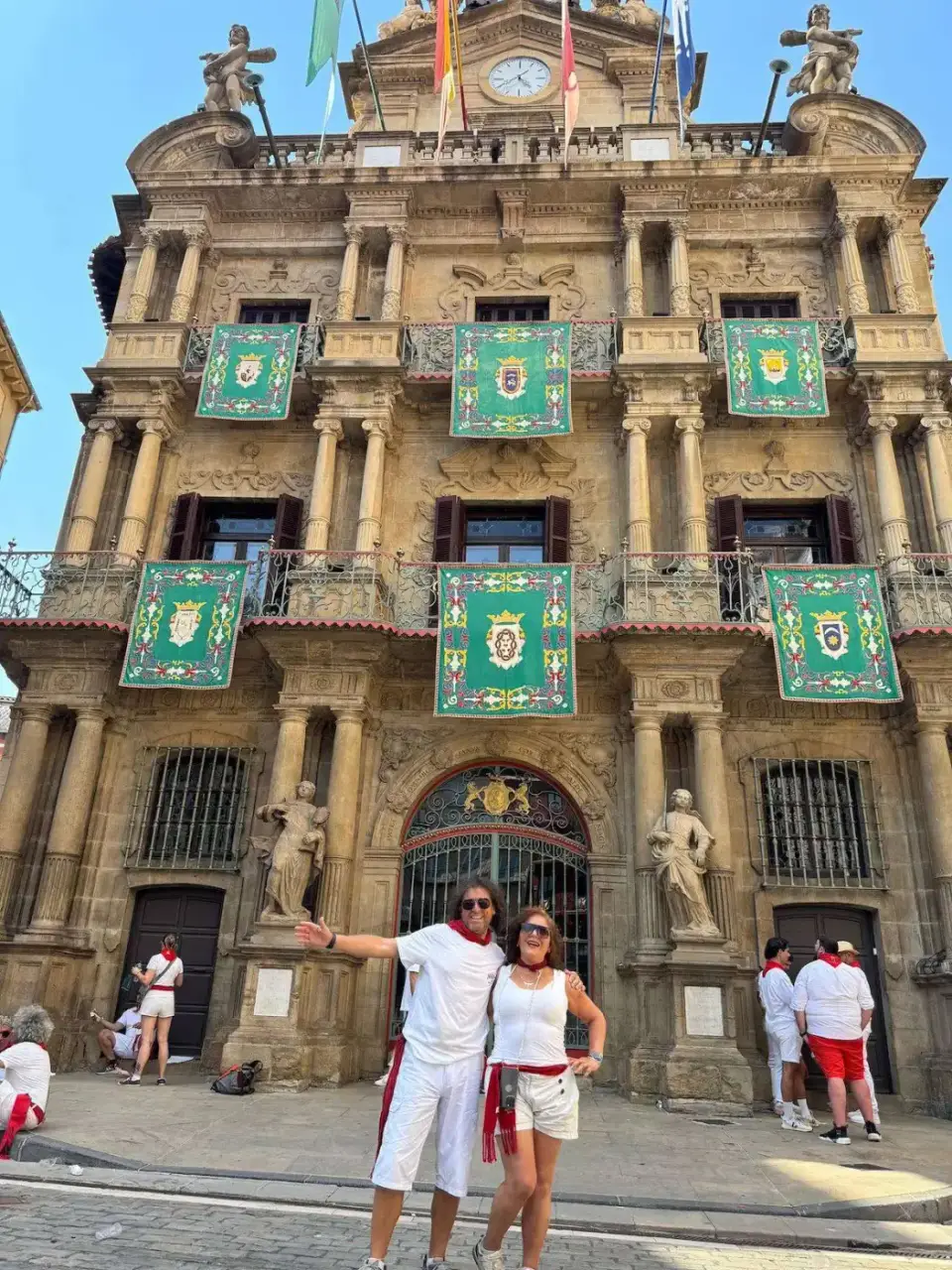 Jorge y Paola de blanco y rojo frente al Ayuntamiento de Pamplona