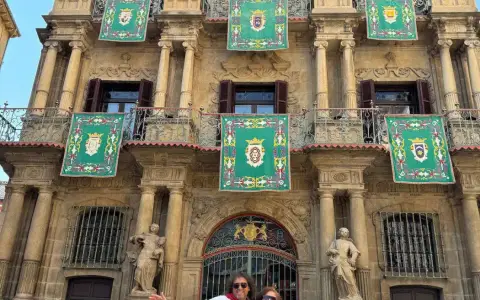 Jorge y Paola de blanco y rojo frente al Ayuntamiento de Pamplona