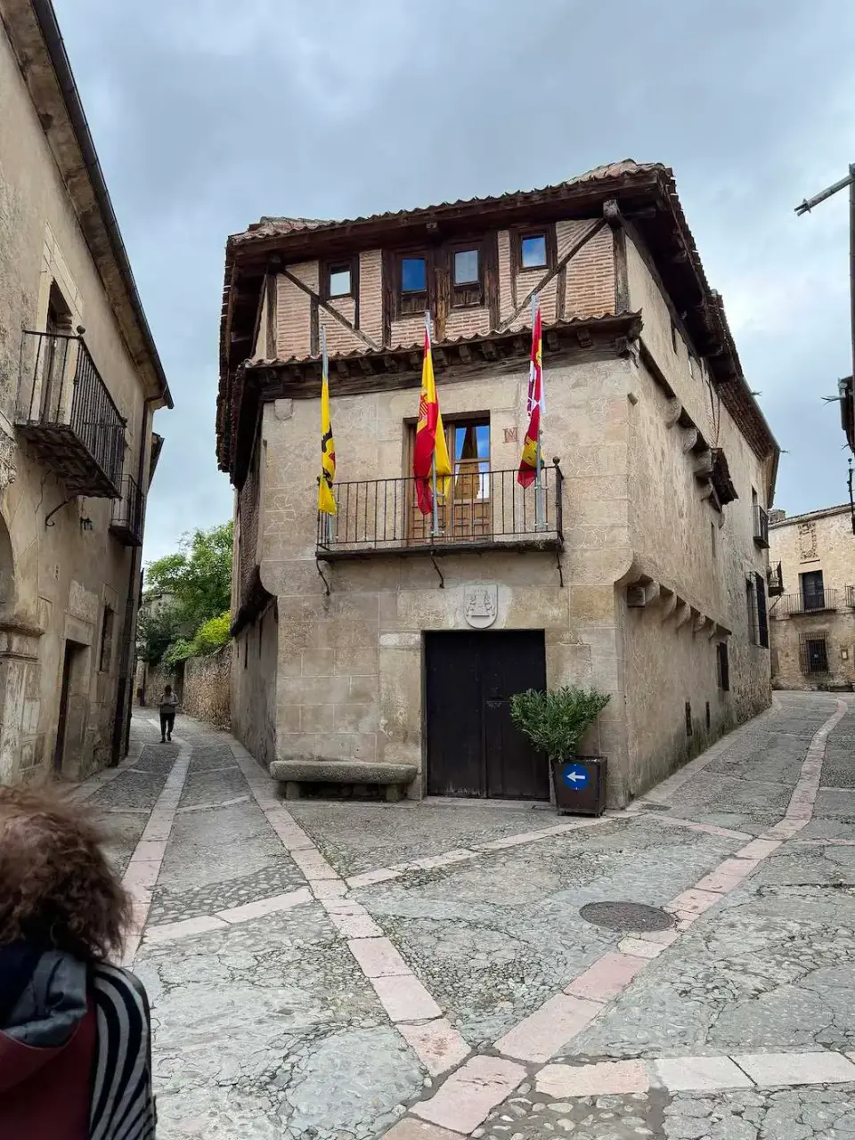 Casona con galería de madera y banderas en el centro del pueblo