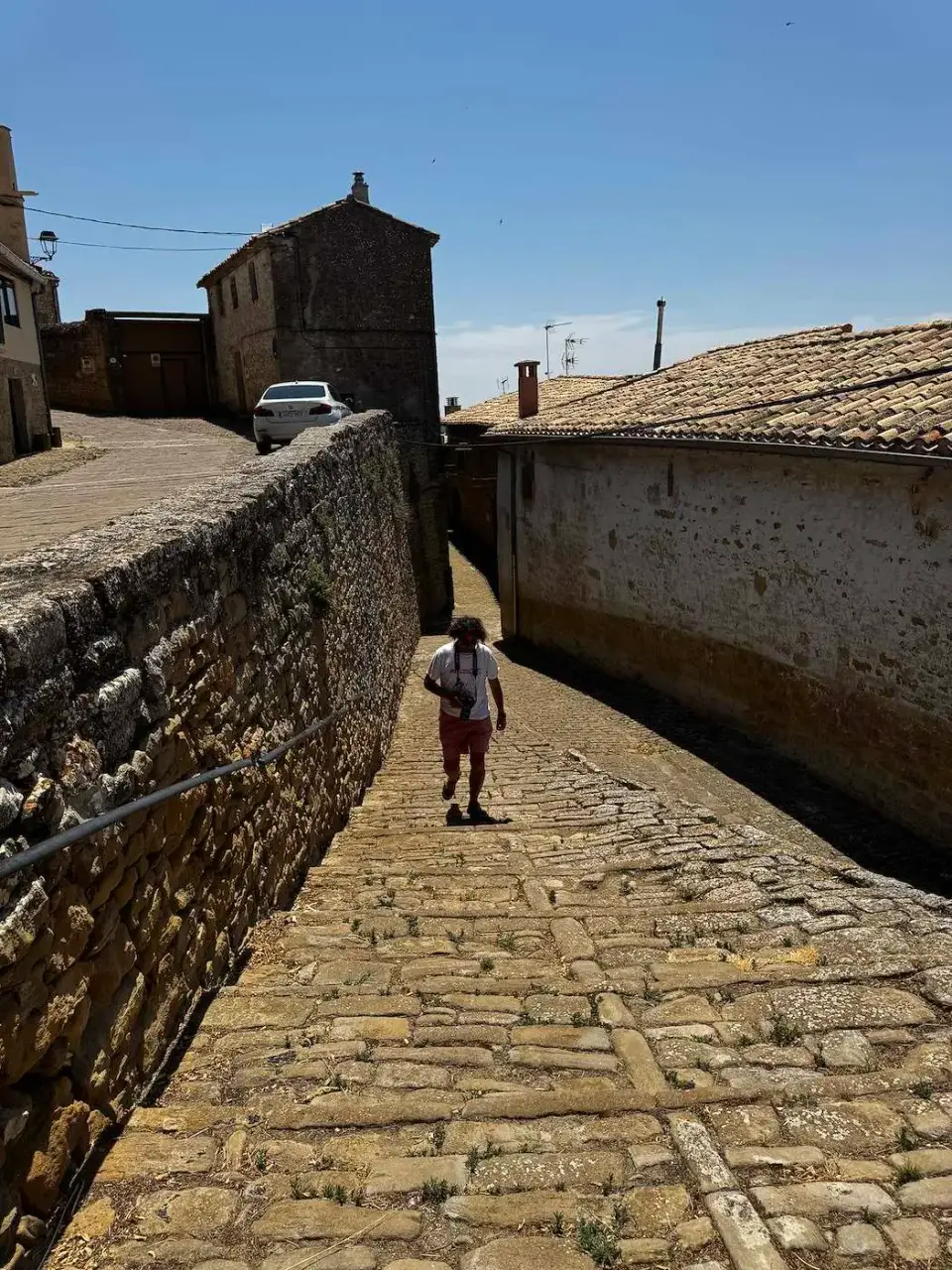 Calle empedrada en pendiente entre muros de piedra