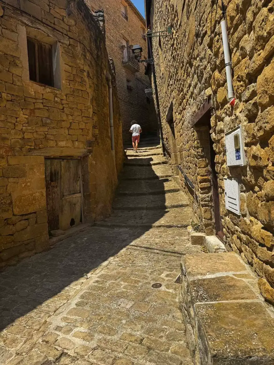 Callejón empinado con escalones entre casas de piedra