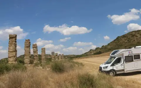 La autocaravana junto a los pilares del acueducto romano de Los Bañales